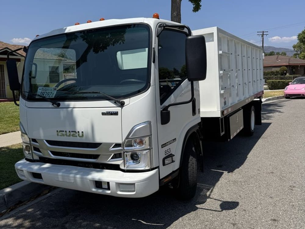 JR Palm Bay junk hauling truck parked on the street outside a job
