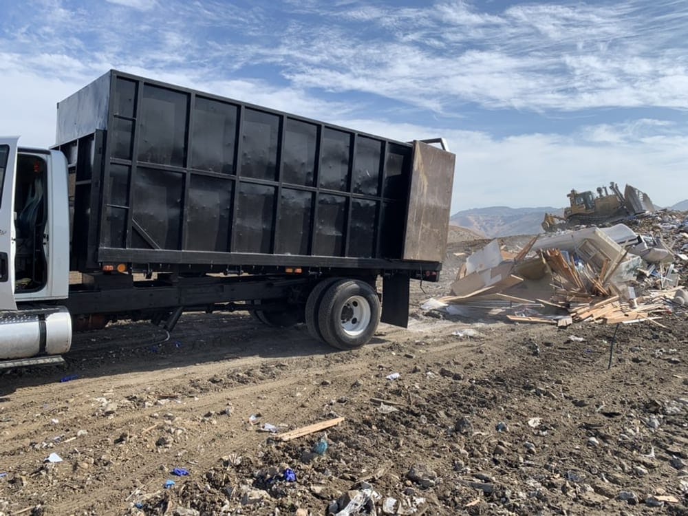 Hauling truck loading bulk commercial waste at a retail and warehouse site