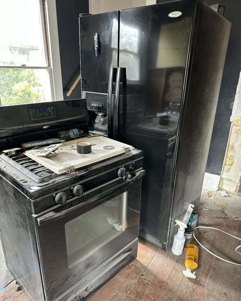 Old refrigerator and gas range ready for appliance removal in a Palm Bay kitchen