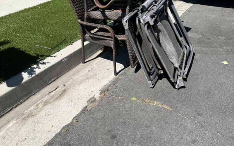 Folding chairs and office furniture stacked at the curb in Palm Bay