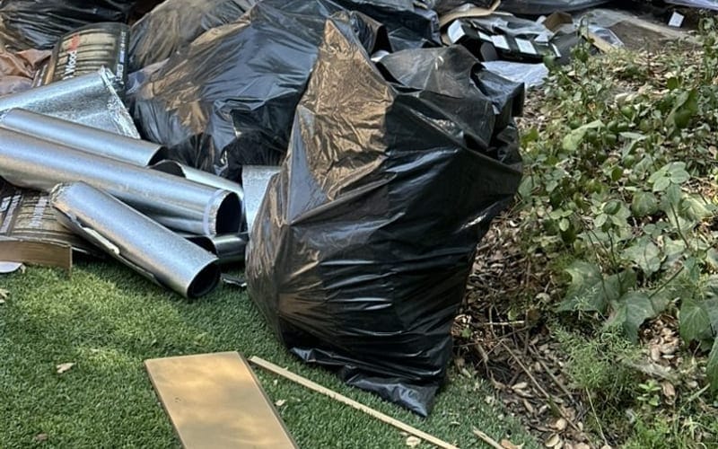 Bagged renovation debris and metal siding cleared after a build in Palm Bay